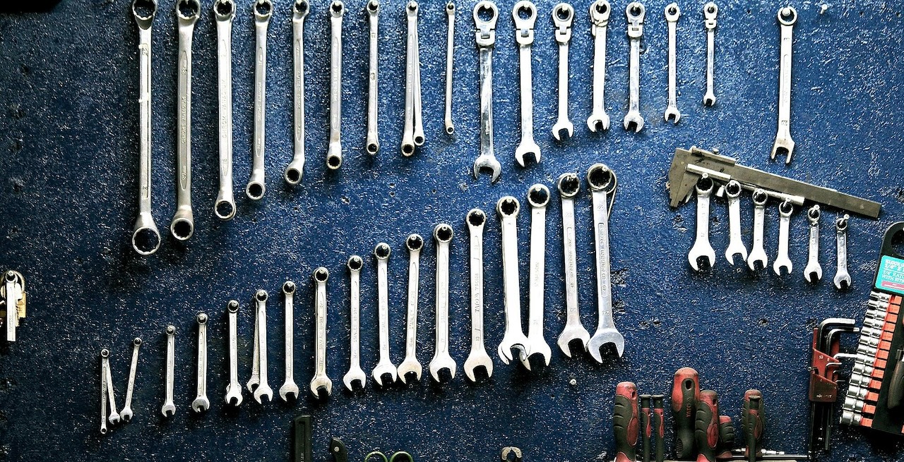 A bunch of wrenches on a tool rack.